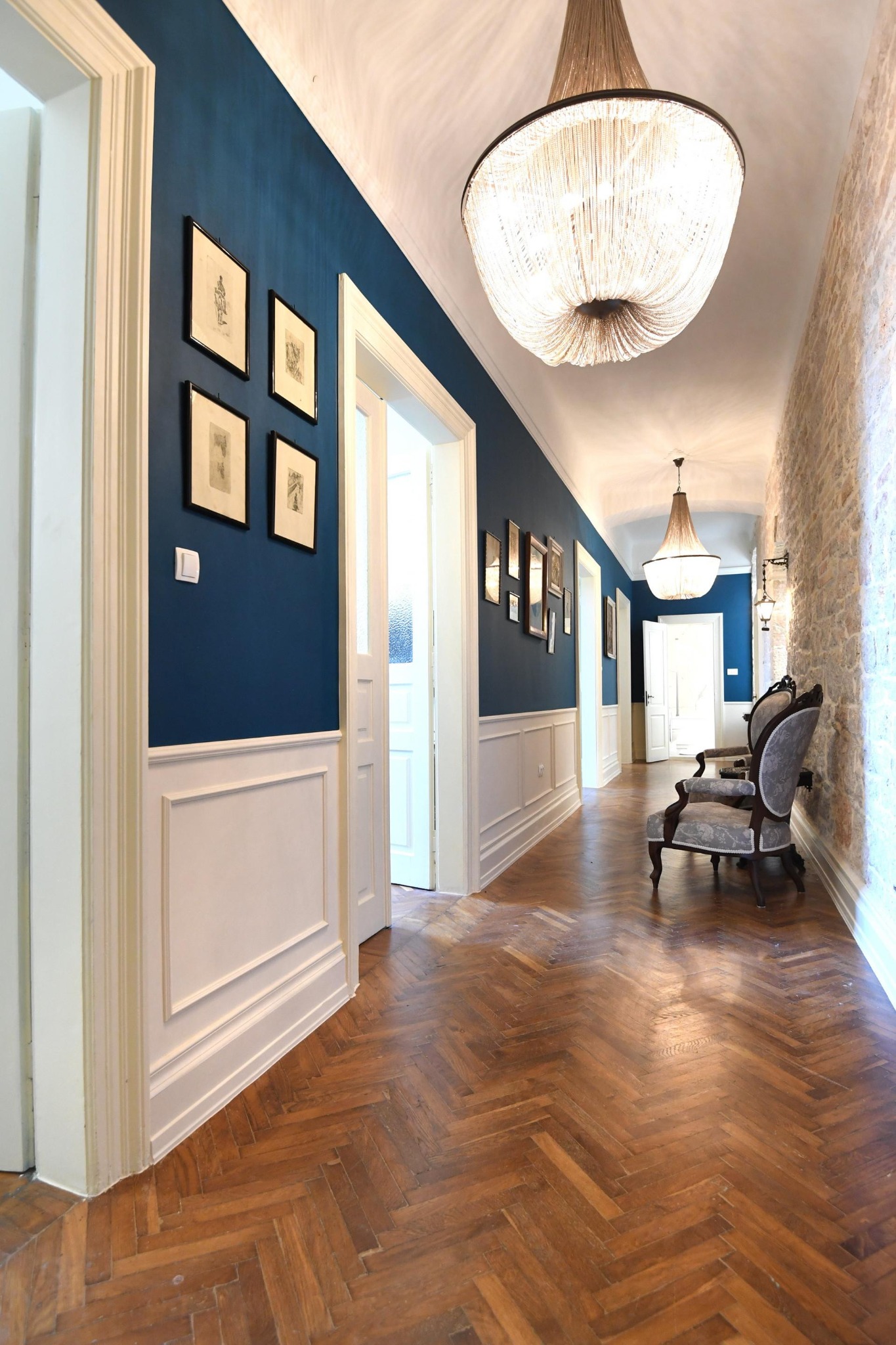 Blue and stone hallway with chandeliers