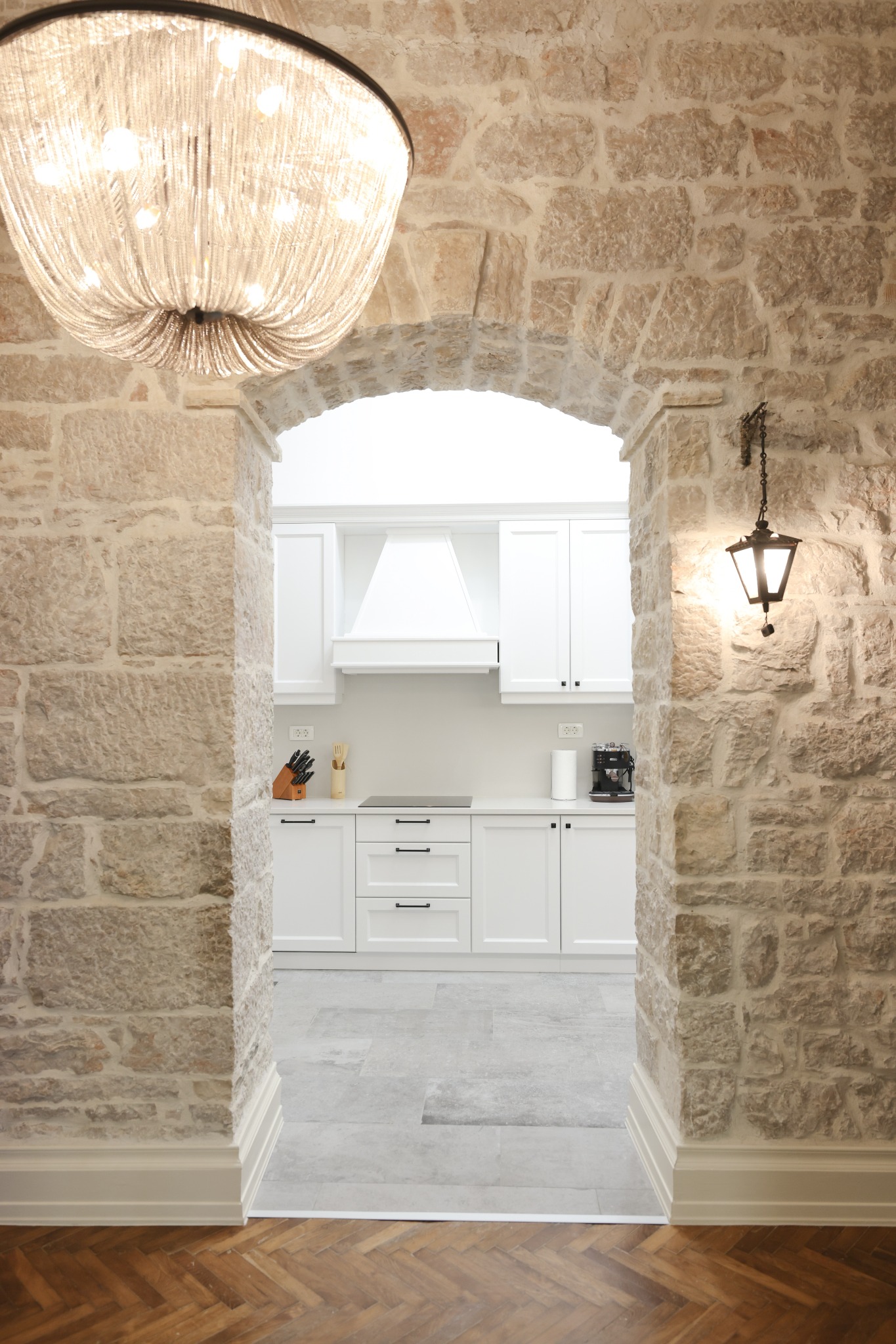 Original stone arch opening into the modern kitchen